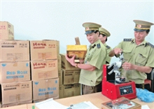 Cán bộ Đội Quản lý thị trường số 9 (Chi cục Quản lý thị trường tỉnh) kiểm tra lô hàng bánh kẹo giả, không rõ nguồn gốc xuất xứ vừa bị bắt giữ, tịch thu. 